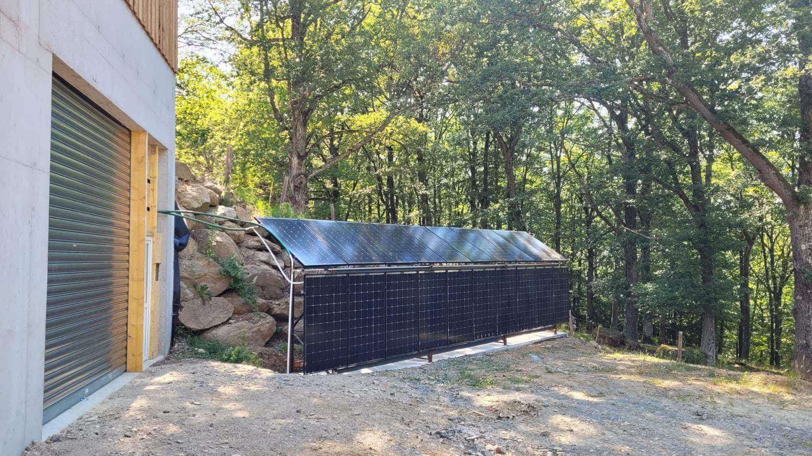 Rangée de capteurs solaires au sol installée en lisière de forêt